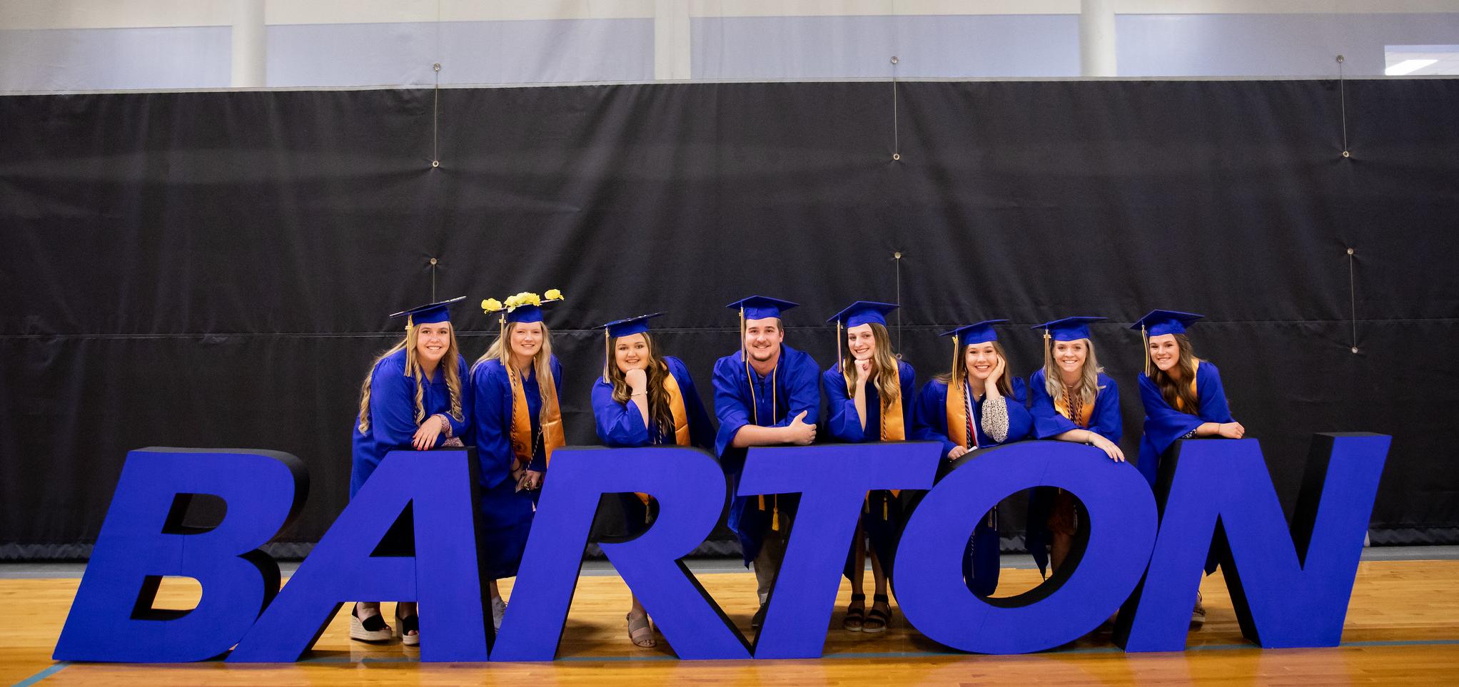 Graduates pose with Barton letters