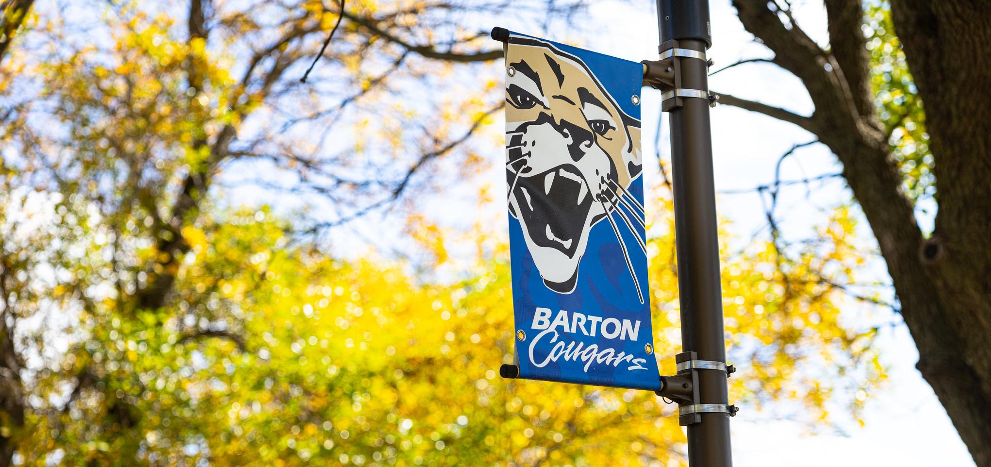 Pole banner on barton county campus reads Barton Cougars